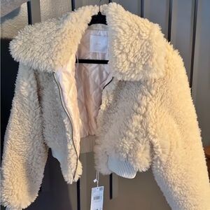 Fux shearling and a spread collar. Cropped jacket with sporty rib-knit trim.
